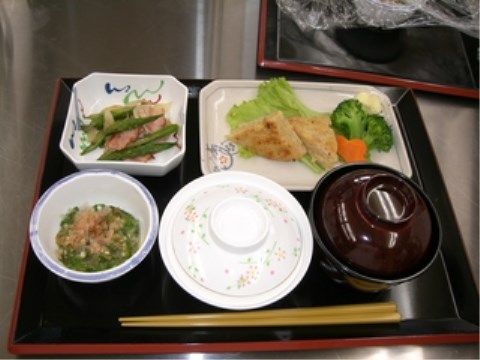 ブロッコリーと人参が添えられた焼き物と小鉢が並んだ食事