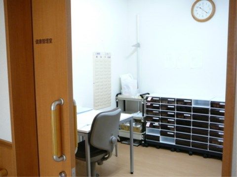 ラベルがつけられた引き出しのある棚が奥に見えている事務所