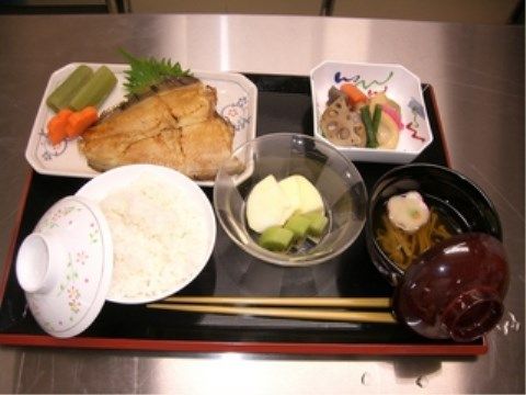 蓋つきの茶碗に盛られたごはんとみそ汁、焼き魚がメインの食事
