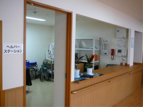 壁に手すりが付いており、観葉植物が飾られているヘルパーステーション