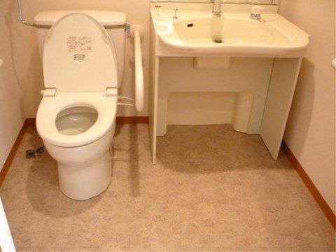 「ニチイケアセンター豊平」の居室トイレ。洗面台とトイレを一緒にし、入居者様にかかる負担を軽減を目的としている。