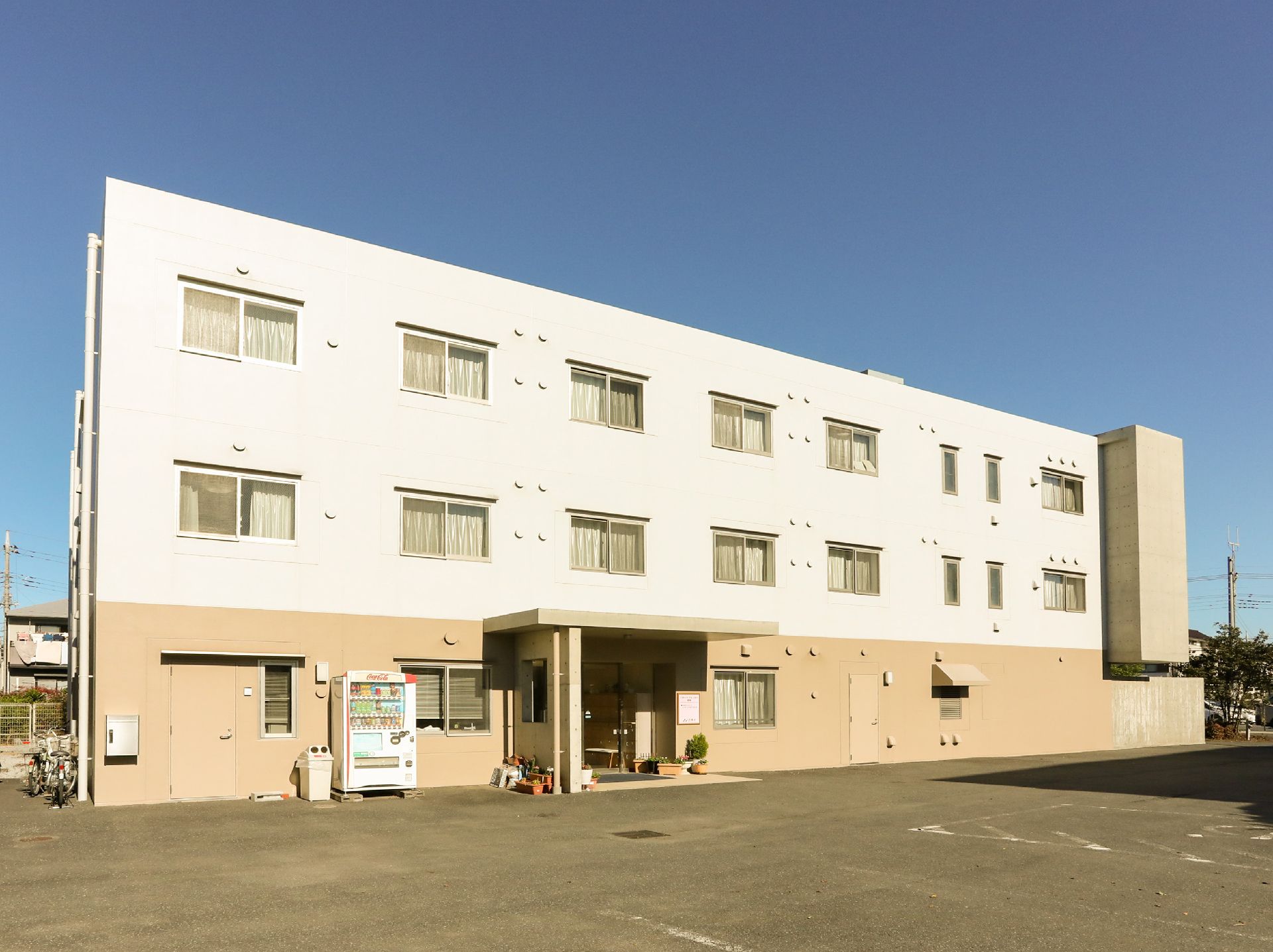 ツートーンカラーの建物と自動販売機