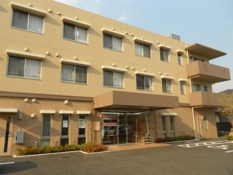 ニチイケアセンター越谷の外観。茶色がおしゃれな大きな施設外観です。大きなエントランスルーフが特徴となっております。