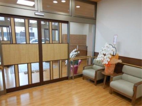 「ニチイケアセンター天神川」のエントランスホール。ソファーチェアの間には、胡蝶蘭が飾られている。