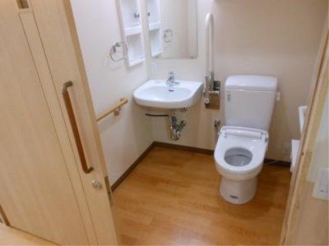 「ニチイケアセンター天神川」の居室・トイレ。トイレと洗面台を一緒にすることで、体への負担を和らげる目的もある。