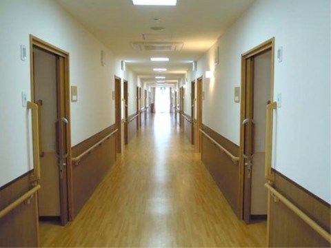 「ニチイケアセンターひめじ的形」の廊下。居室扉を横開きスライドになっているので、廊下に幅を取らせない。