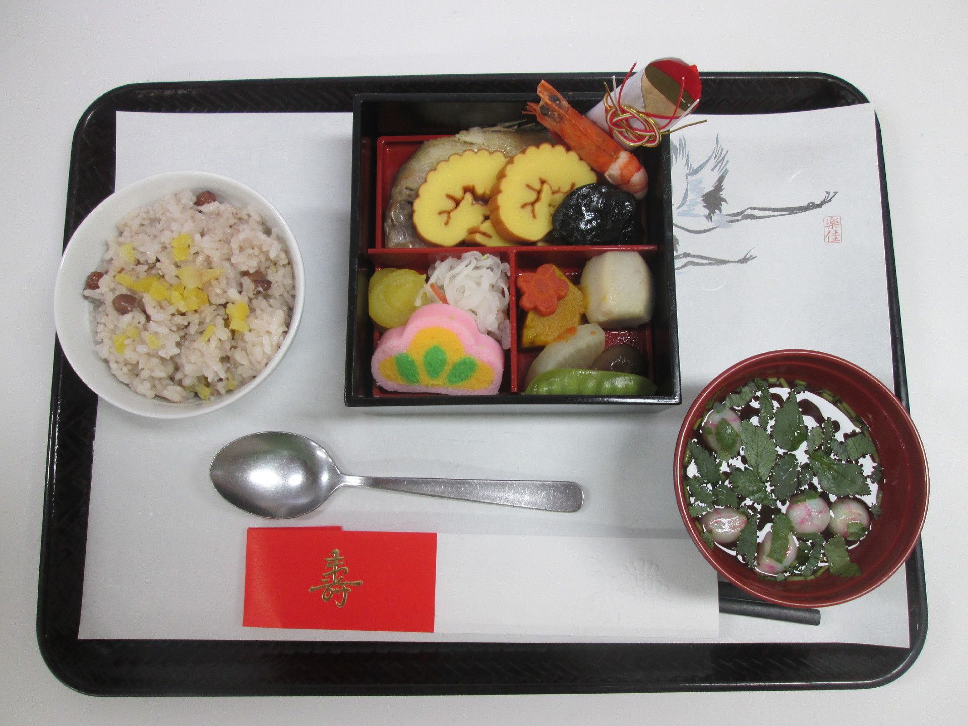 祝箸と共に黒いプレートに並べられている祝いの記念食