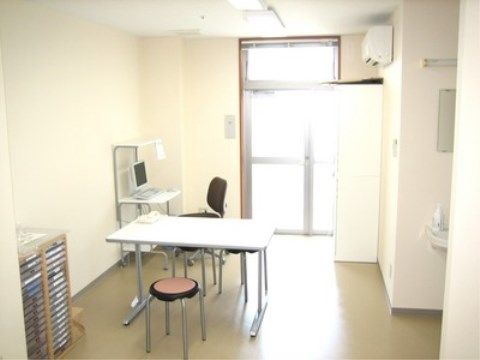 サッシ扉から陽射しが入り、白を基調に整えられた健康管理室