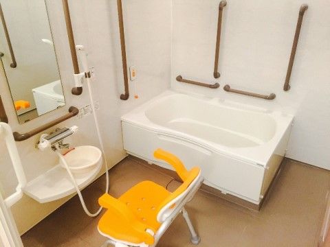 「ニチイケアセンターひめじ広畑」の一般浴室。滑りにくいタイル、介助手すりを施すことで、滑り事故を防いでいる。