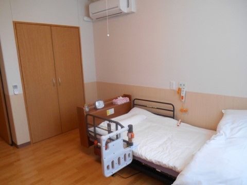 「ニチイケアセンター奈良葛城」の居室。介護ベットを設置しており、車椅子から移りやすいよう手すりを備え付けている。
