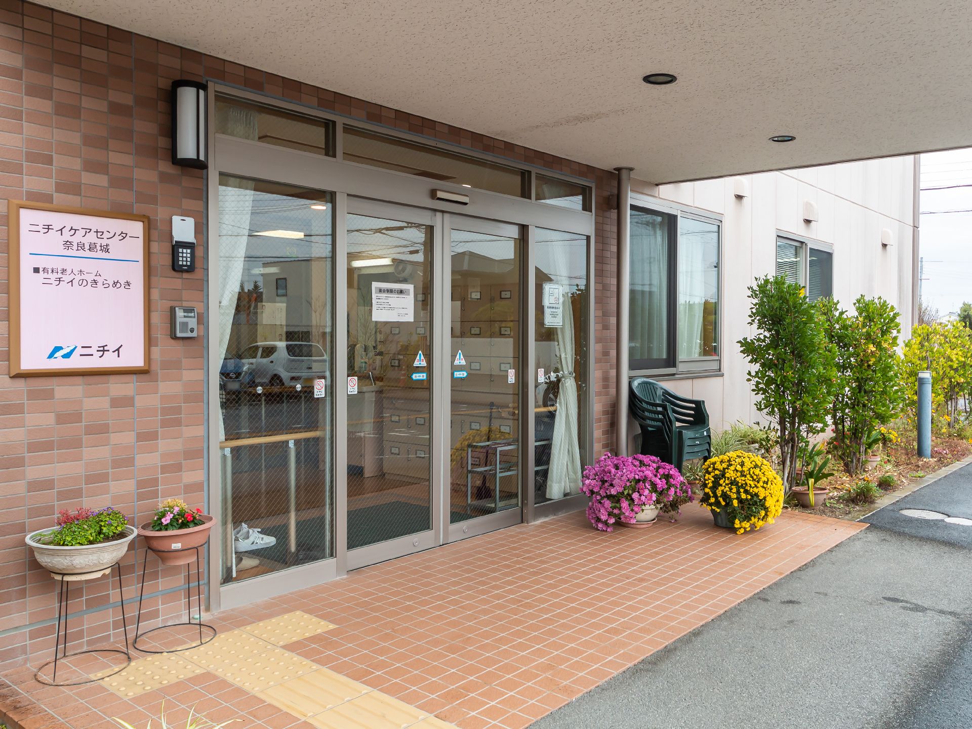 入口前に花などが置かれている玄関