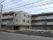 「ニチイケアセンター仙台市名坂」の外観。住宅や公共の施設佇む肌色の3階建ての建物で駐車場を付いている。