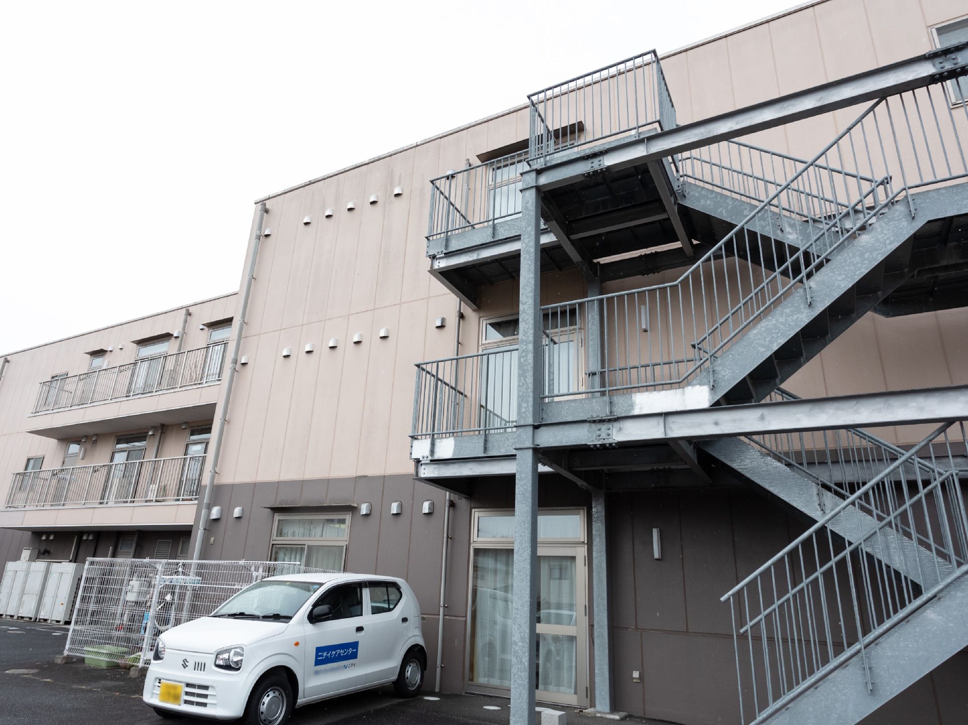 施設の車が停まっている外観