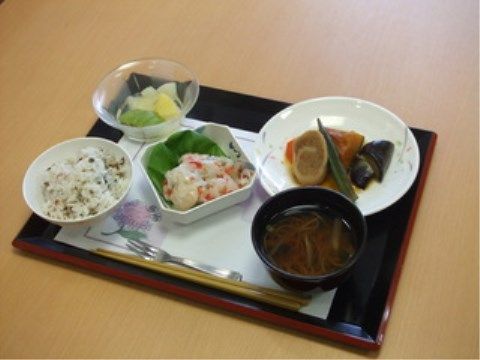 黒いプレートにランチョンシートが敷かれ配置された一汁三菜の献立