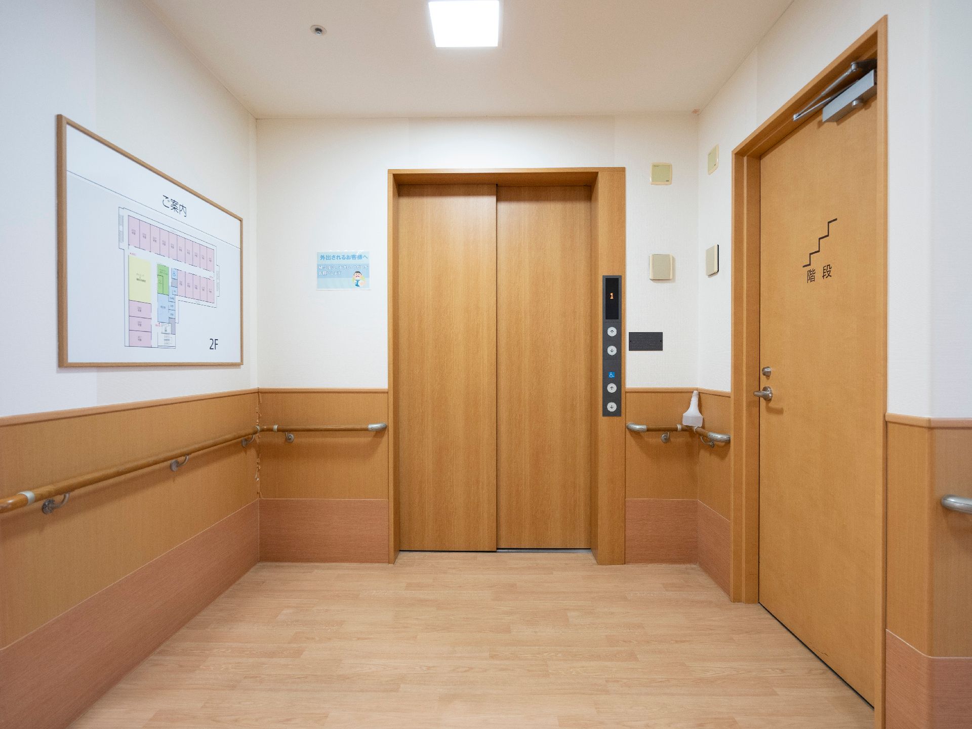 バリアフリー完備で、床の段差が解消され、壁に手すりが設置されている廊下