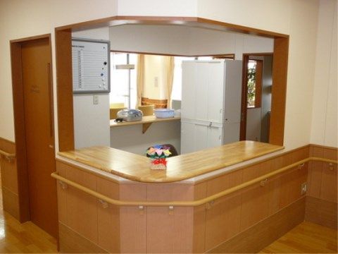 木製カウンターに沿って手すりが設置され、茶色に統一された受付