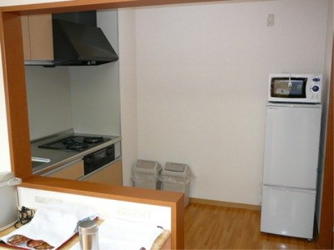 白い冷蔵庫の上に電子レンジを置いているキッチンスぺース