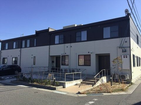 スロープが完備されたツートーンカラーの２階建て施設の外観