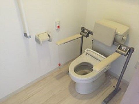「住宅型有料老人ホーム トラストリー長久手」のトイレ。左右に肘掛け、右壁には緊急時の呼び出しのコールを設置している。