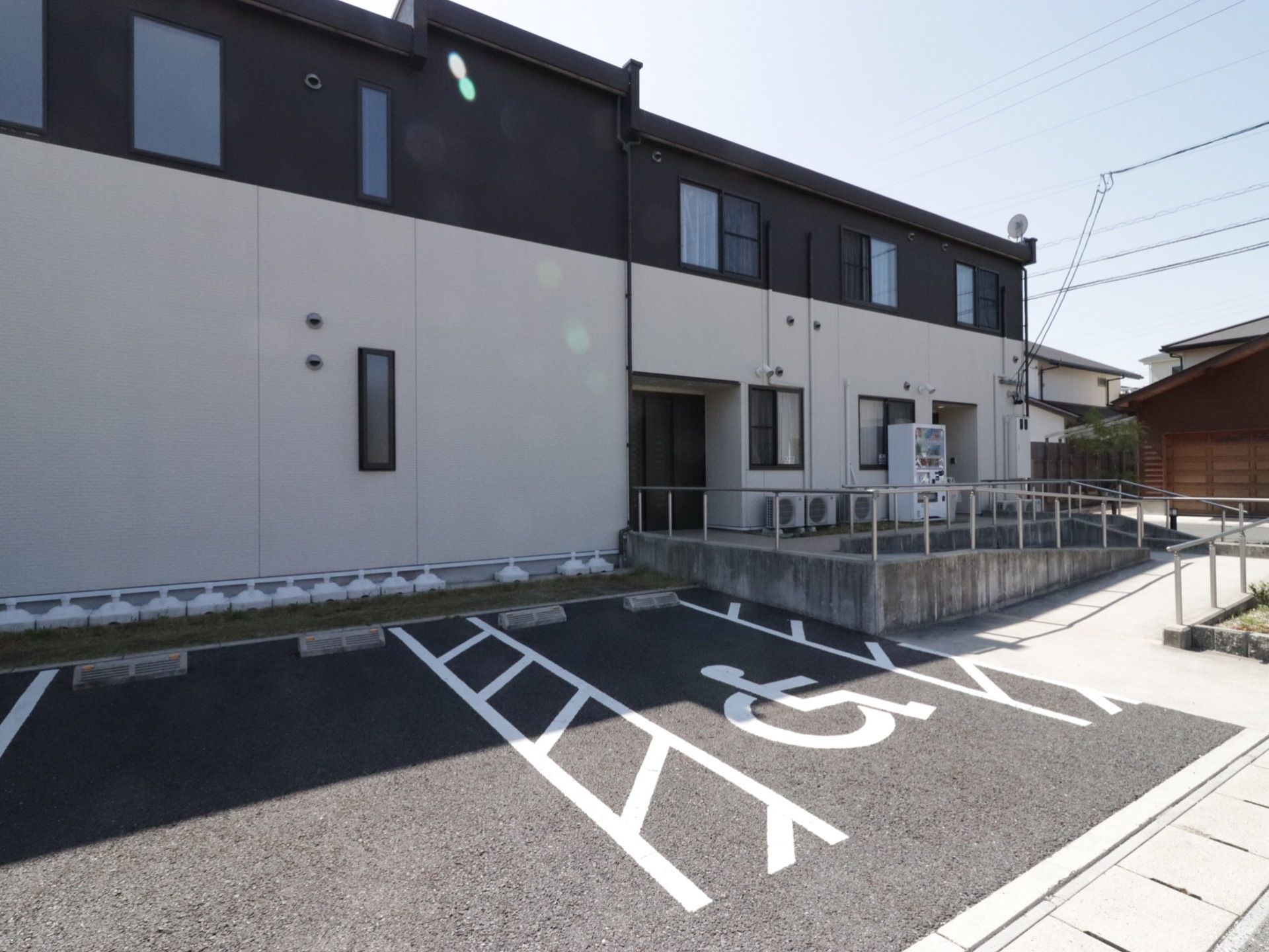 外壁は白黒のツートンの２階建てである。車椅子専用車も停められる駐車スペースがあり、入口まではスロープがつながっている。