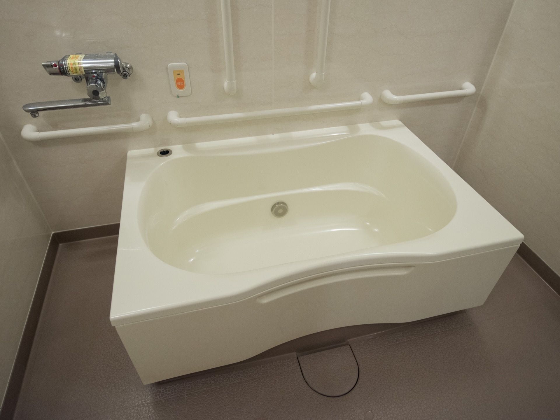 白いバスタブがあり、壁には手すりが縦横に何本も備えつけられている。緊急通報用のボタンも設置されている。