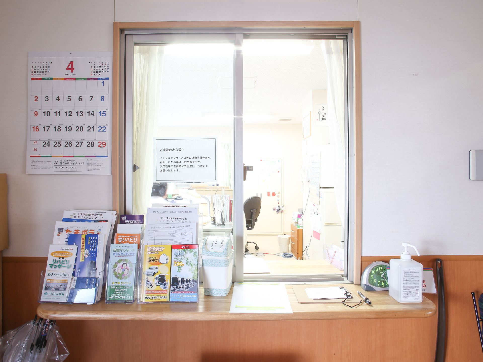 事務室の受付には来館者への注意書きが貼られている。冊子などを多数用意してある。時計に消毒用アルコールも完備している。