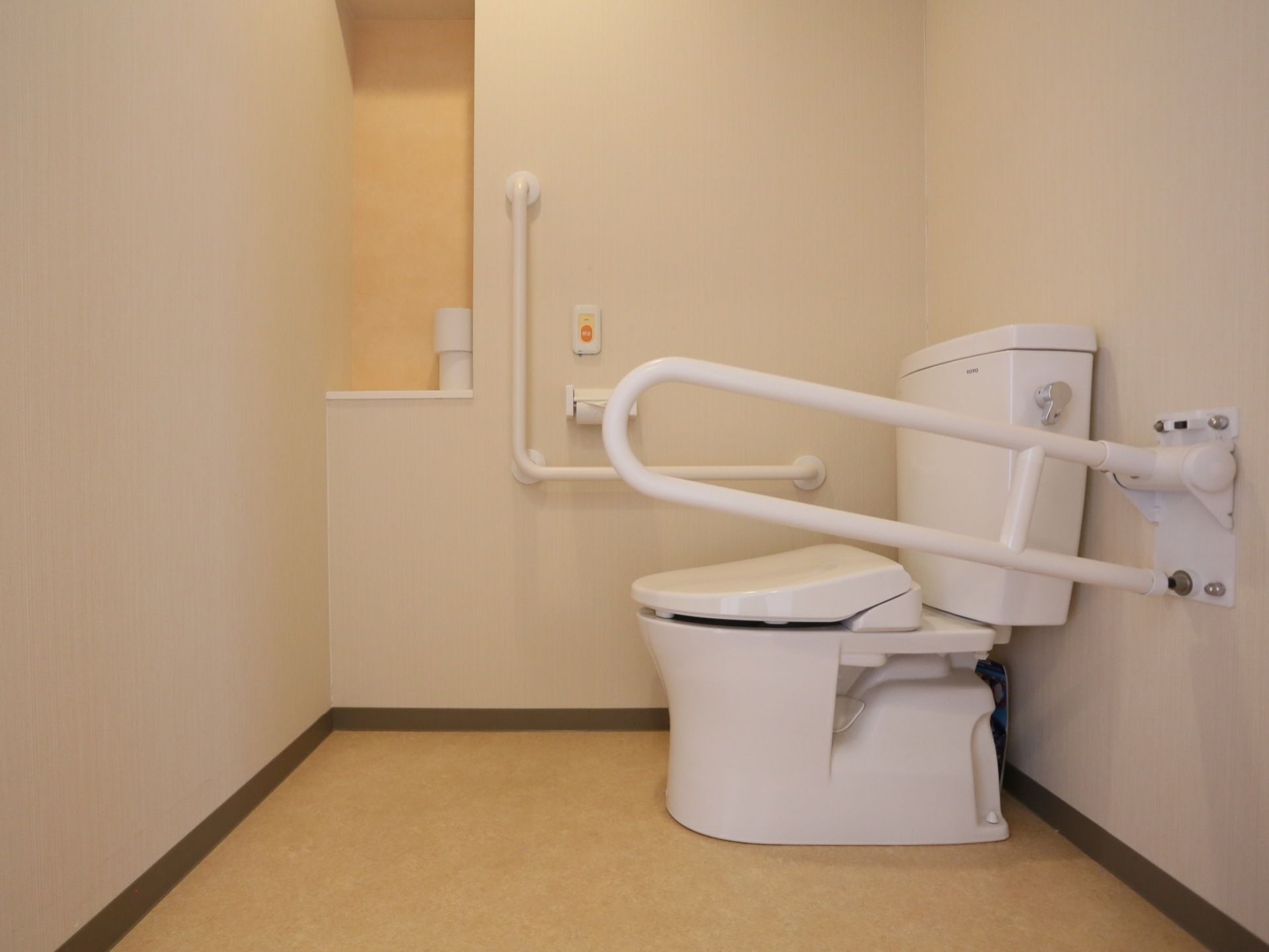 トイレの壁には緊急呼び出しブザー、可動式手すりやL字型手すりが設置され、広くスペースが確保されている。