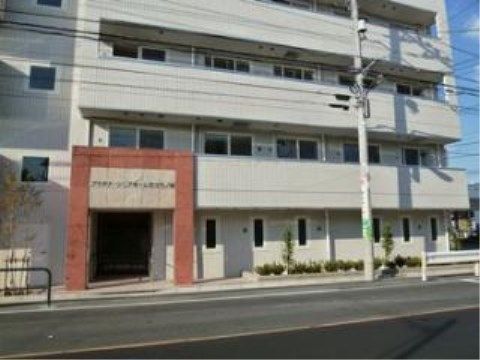 勾配のある地に立地しているライトグレー系の施設外観