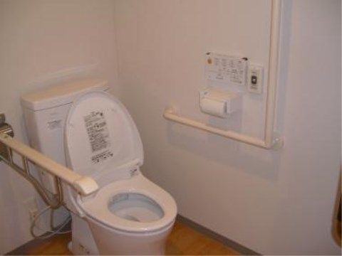 「プラチナ・シニアホーム足立竹ノ塚」のトイレ。介助手すりで、入居者様の立ち上がり時のサポートを行っている。