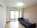 大きな窓がある木目調の床と白色の壁の部屋で、エアコン、電動介護ベッド、緊急時コールボタンが設置されている。