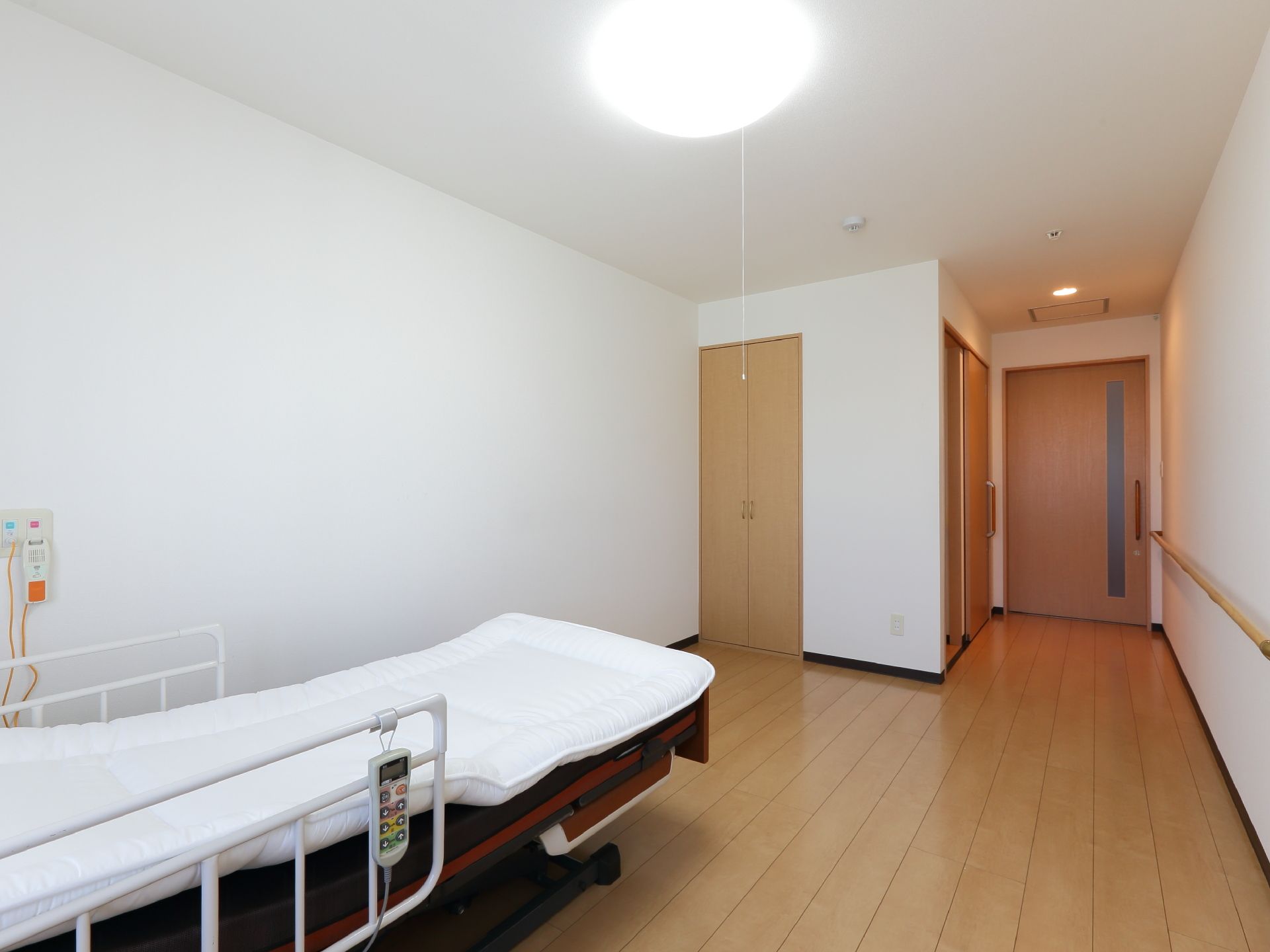 居室には、トイレやクローゼット、洗面台が備わっている。介護ベッドも用意されている。ナースコールが壁に設置されている。