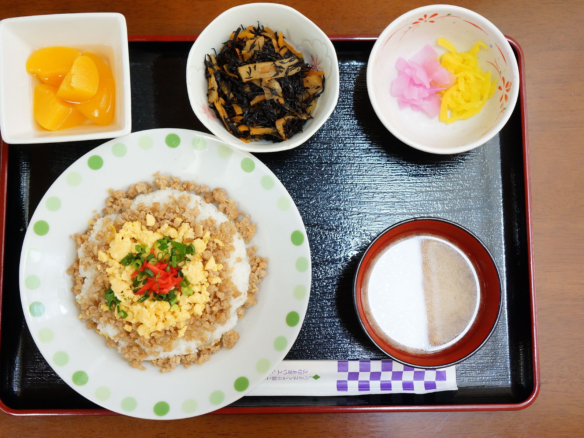 二色のそぼろごはんやひじきの煮物など、栄養バランスが考えられた食事を摂ることができる。みそ汁やフルーツもあり、食事を楽しむことができる。