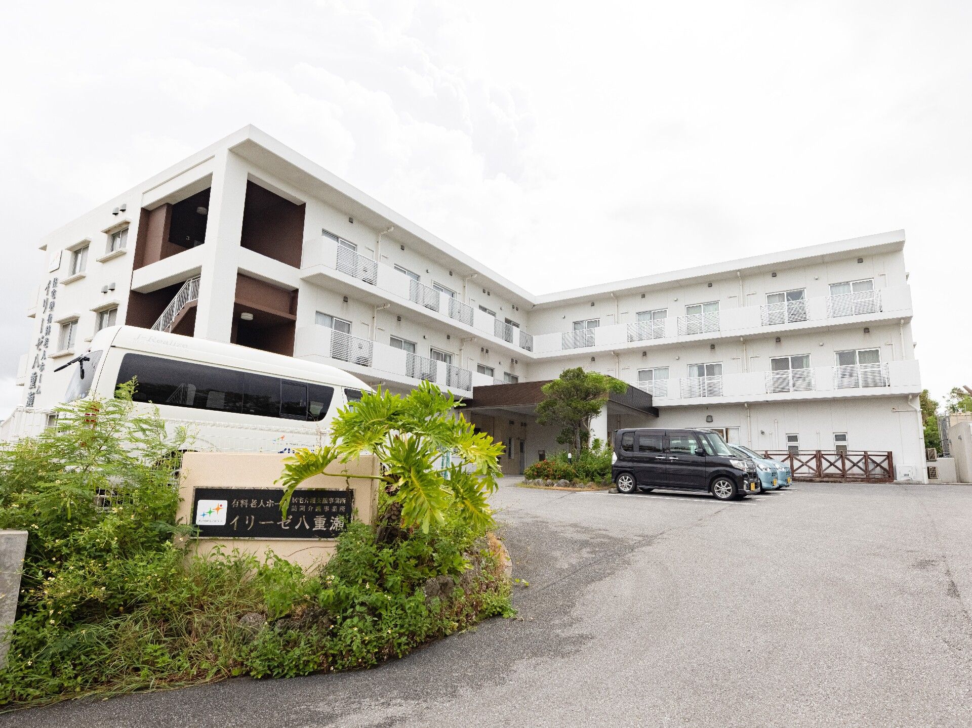 広い敷地に白い3階建ての建物が建っている。玄関ポーチが大きいため、天気が悪くても出入りがしやすくなっている。