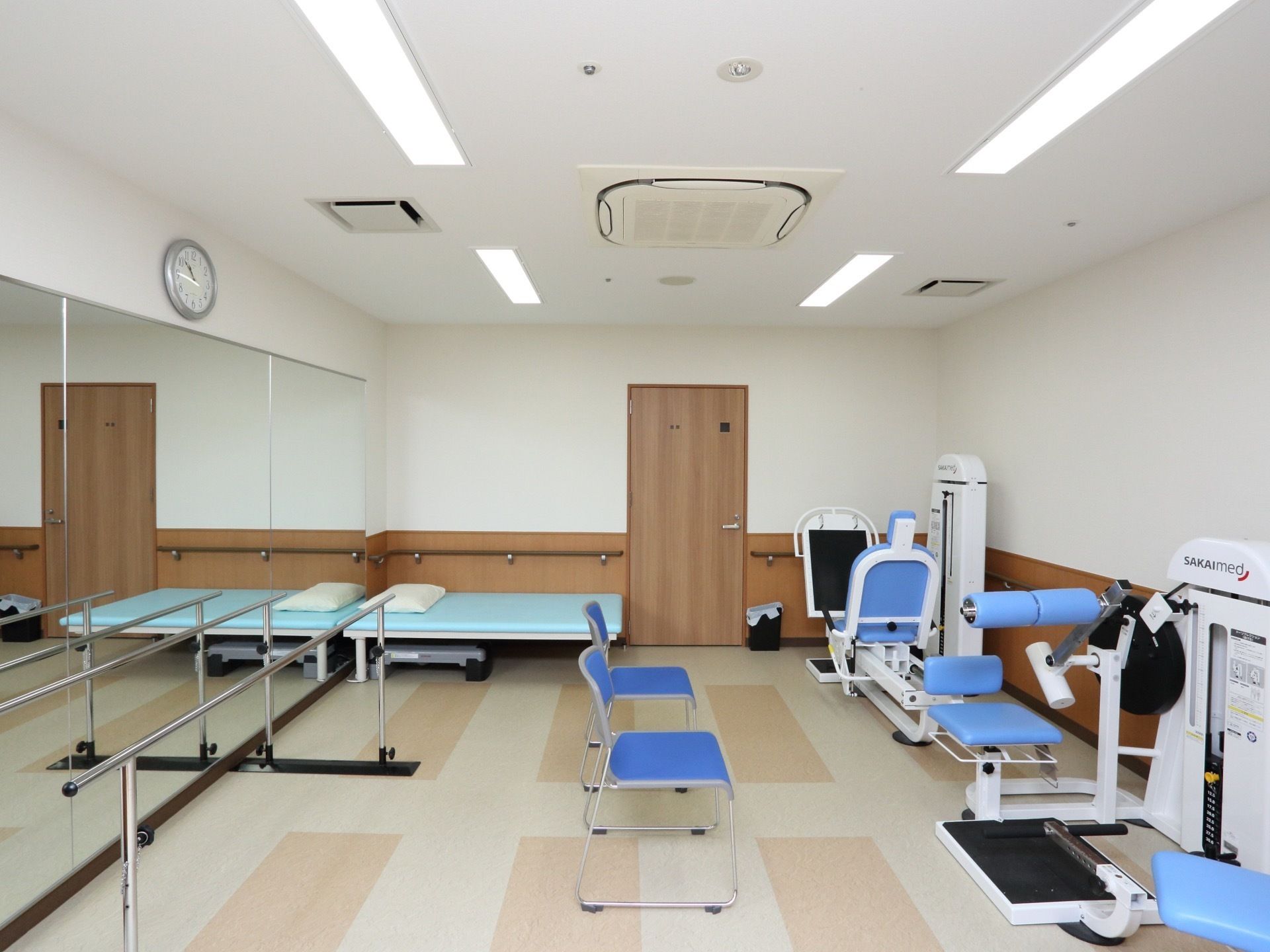 壁に時計や大きな鏡が設置されたリハビリ室には、さまざまな身体機能回復のための機器や器具が用意されている。