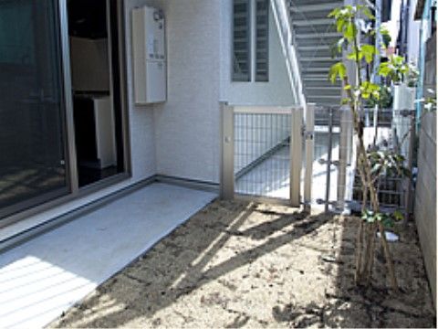 日当たりのよいテラスは木が植えられている。掃き出し窓からテラスへ出入りできる。フェンス扉が取り付けられている。