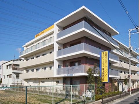 施設は４階建ての建物である。２階から４階までの居室階には、ベランダが設けられている。施設名が書かれた看板が設置されている。