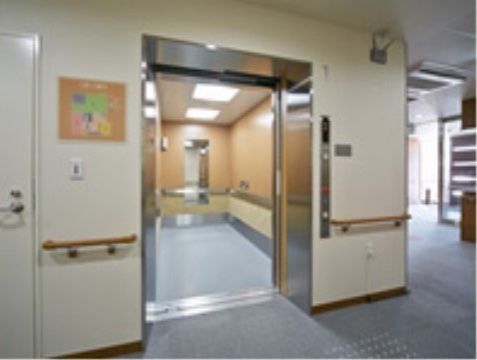 エレベーターの中の壁には、ステンレスの大きめの手すりが設置されている。鏡がついており、車椅子をご利用の方も乗り降りしやすい。