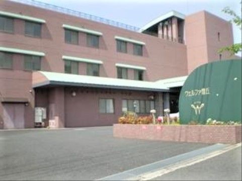 ウェルファ豊丘の外観。暖色がおしゃれな外壁と大きなエントランスルーフが特徴的な外観。