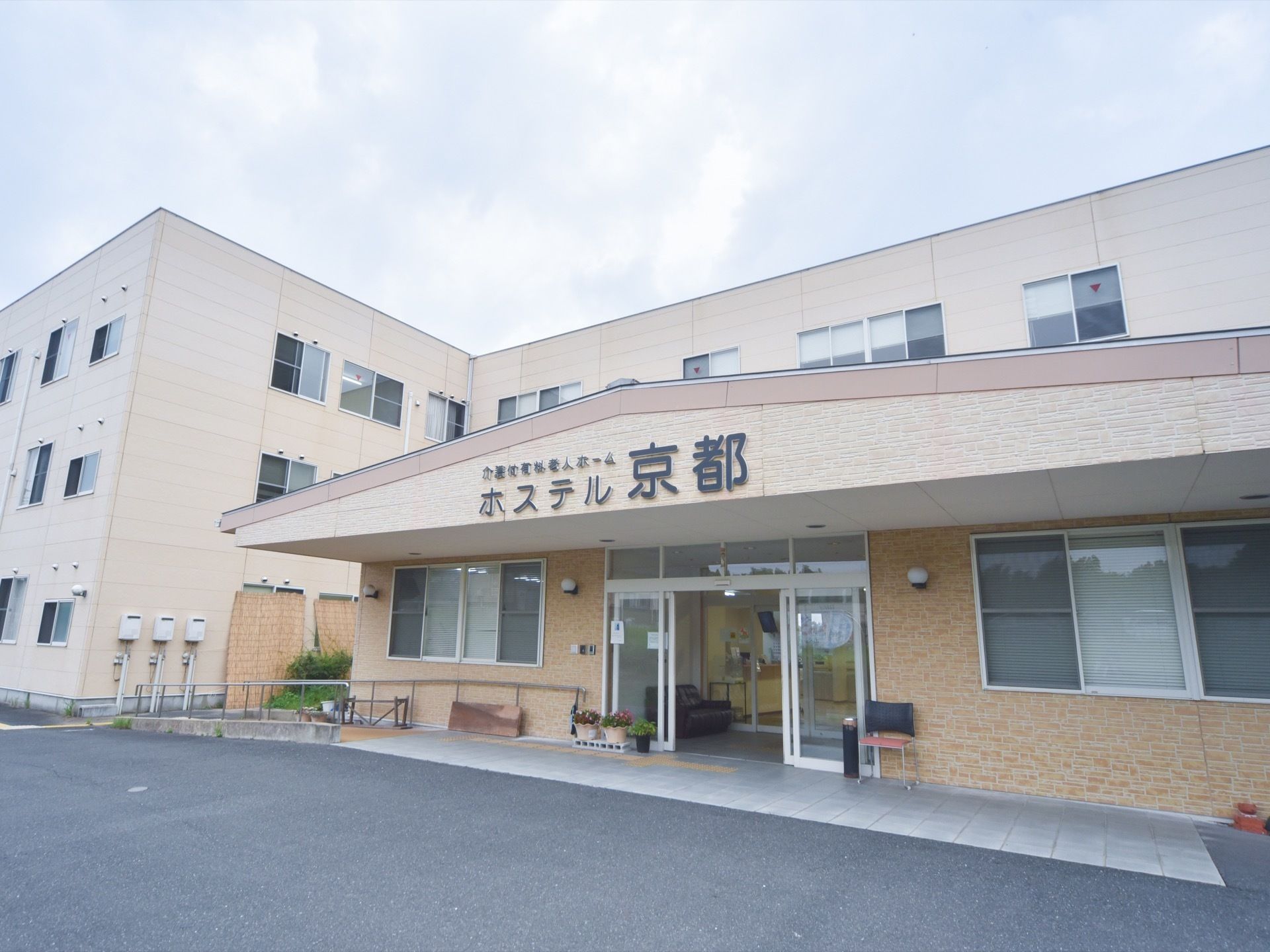 ３階建ての施設の外観。玄関には施設の名前が大きく記されている。地面には段差がなく、車を近くまで着けられるので便利である。