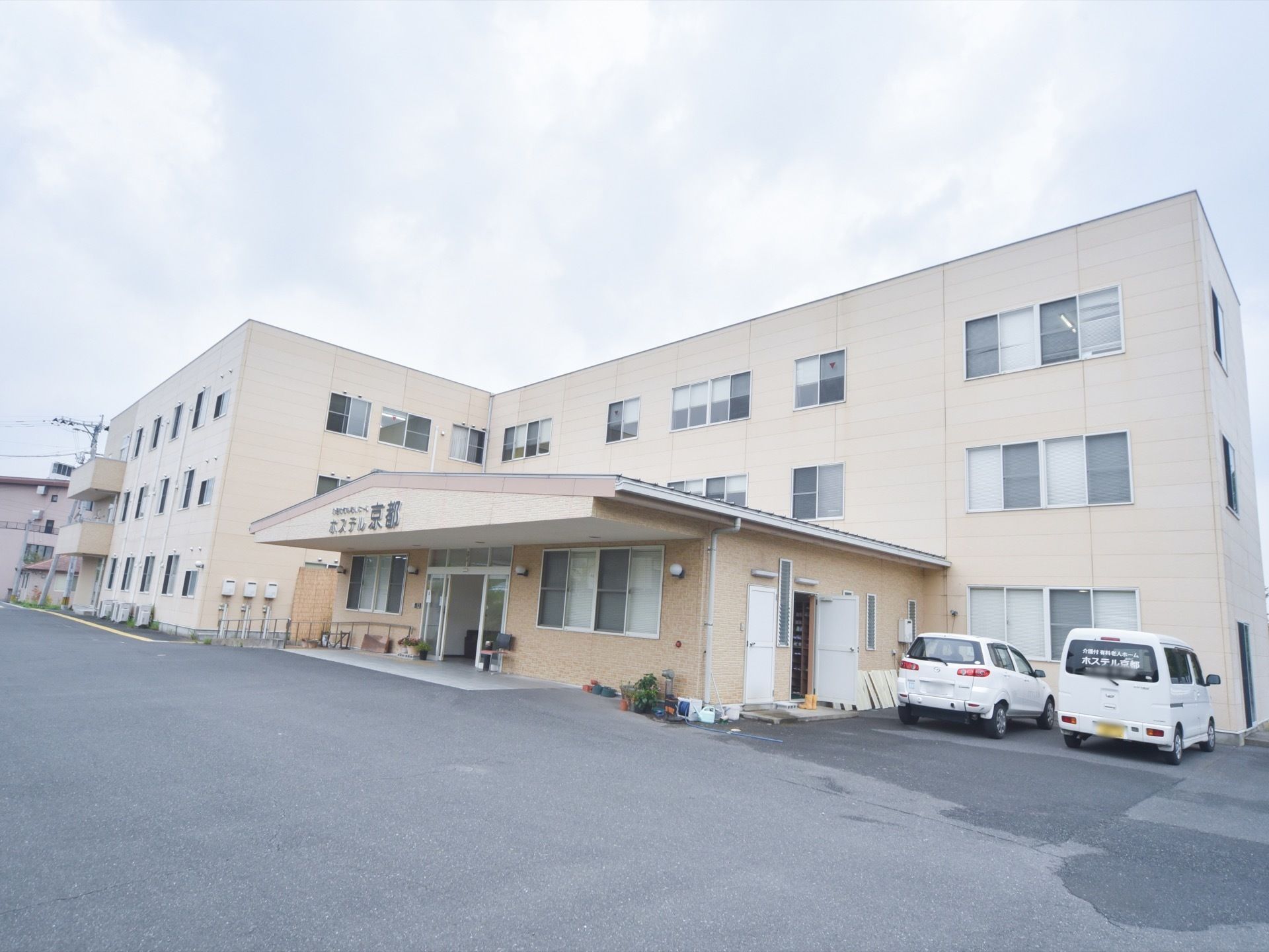 ３階建ての大きなつくりの施設。入口上部には大きな文字で施設名を表記している。壁色は淡いベージュになっている。