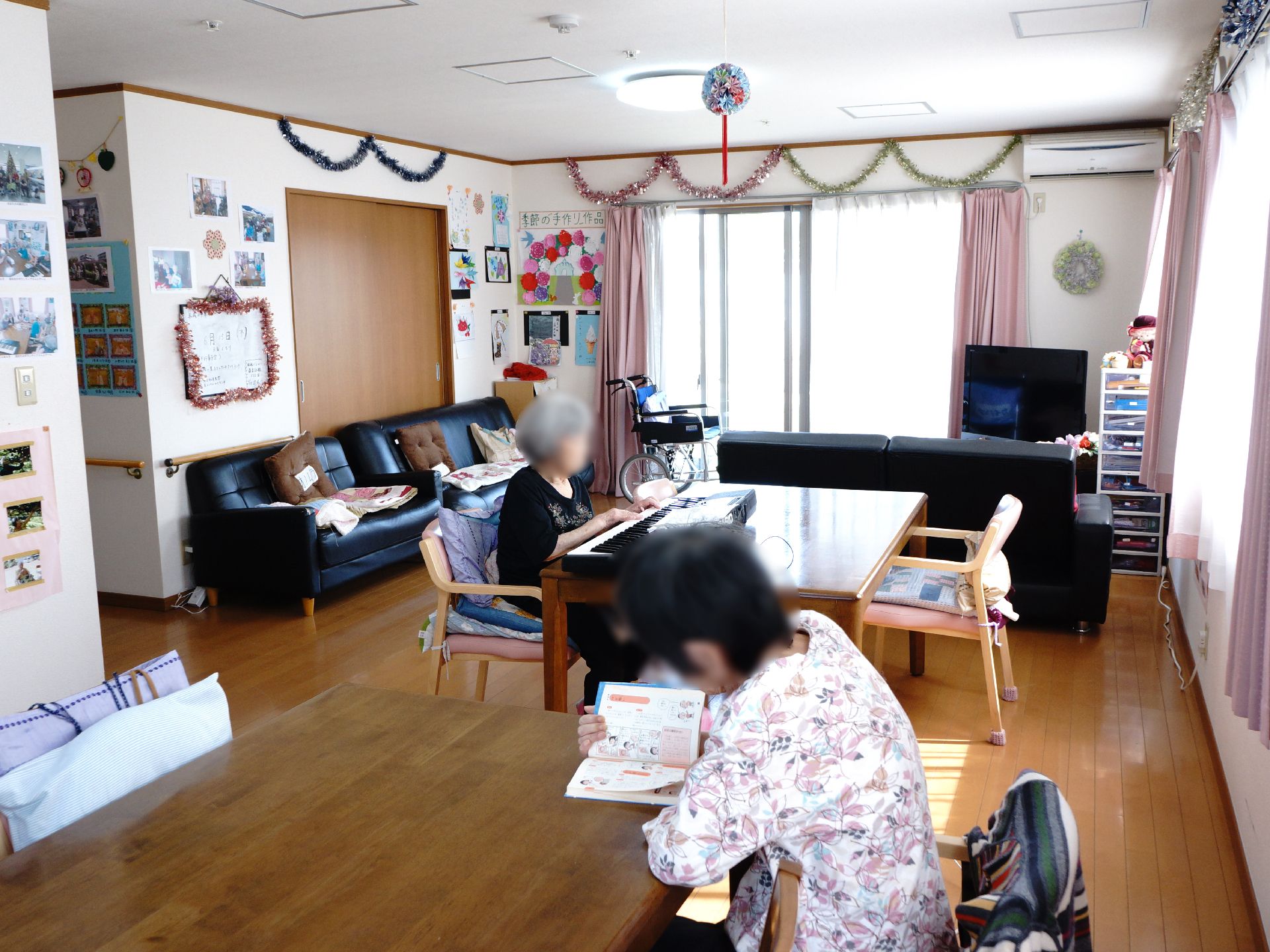 テーブルやソファーなどが置いてあり、入居者の方々は本を読んだり、電子ピアノを弾いたりと思い思いの時間を過ごしている。