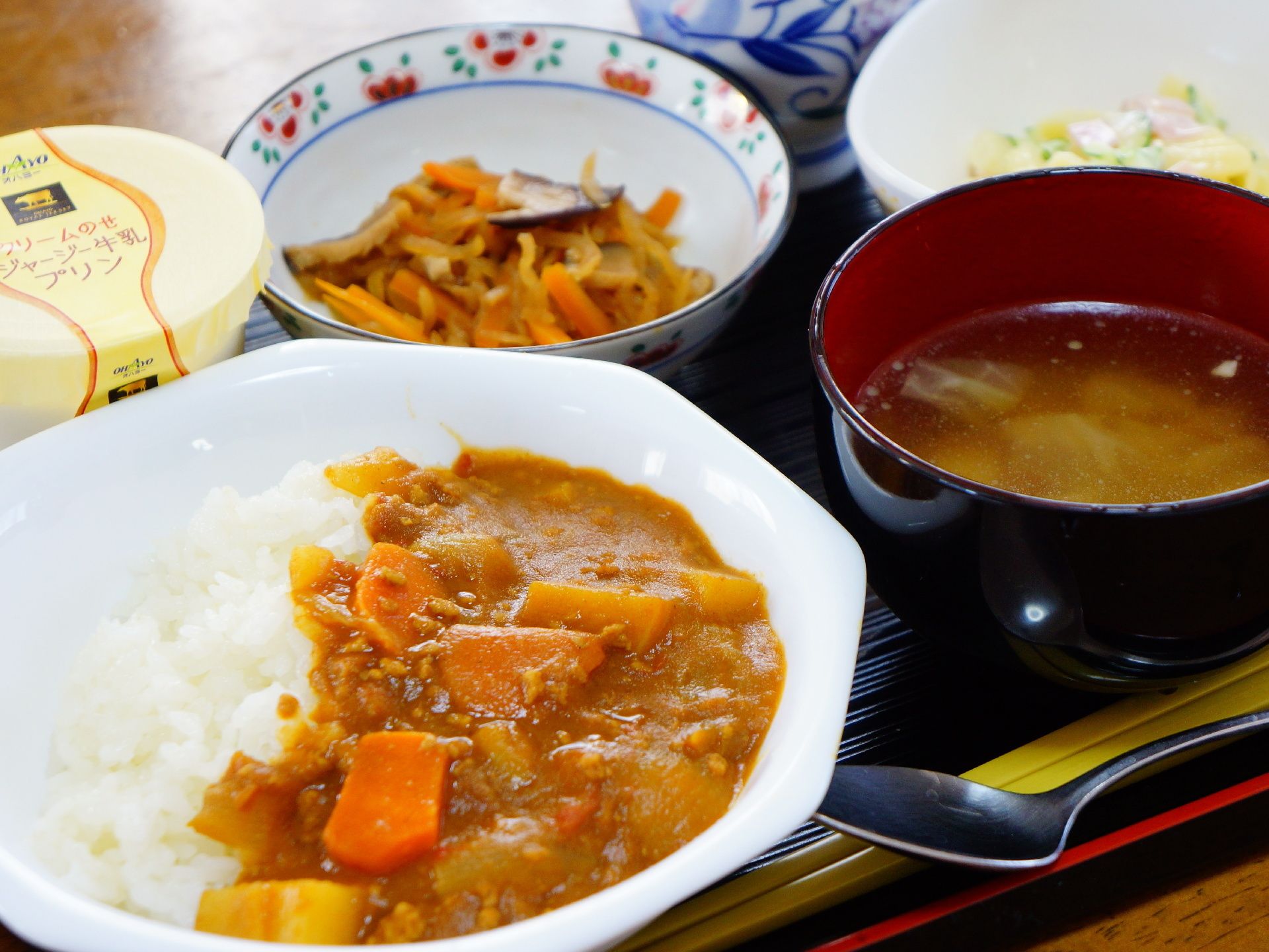 カレー、サラダ、おかず、デザート、汁物などがバランスよく配置され、それぞれ違うお皿に盛りつけられ、量もちょうどいい。