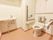 施設内にあるトイレのひとつ。トイレには、背もたれと手すりがついている。また、手洗い場も個室内に設置されている。