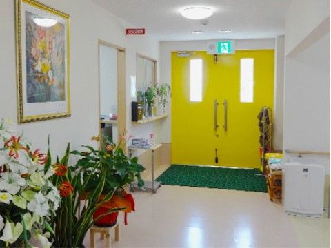 アットホームこころのエントランスホール。黄色いドアが明るさを演出している居心地のいい空間となっております。