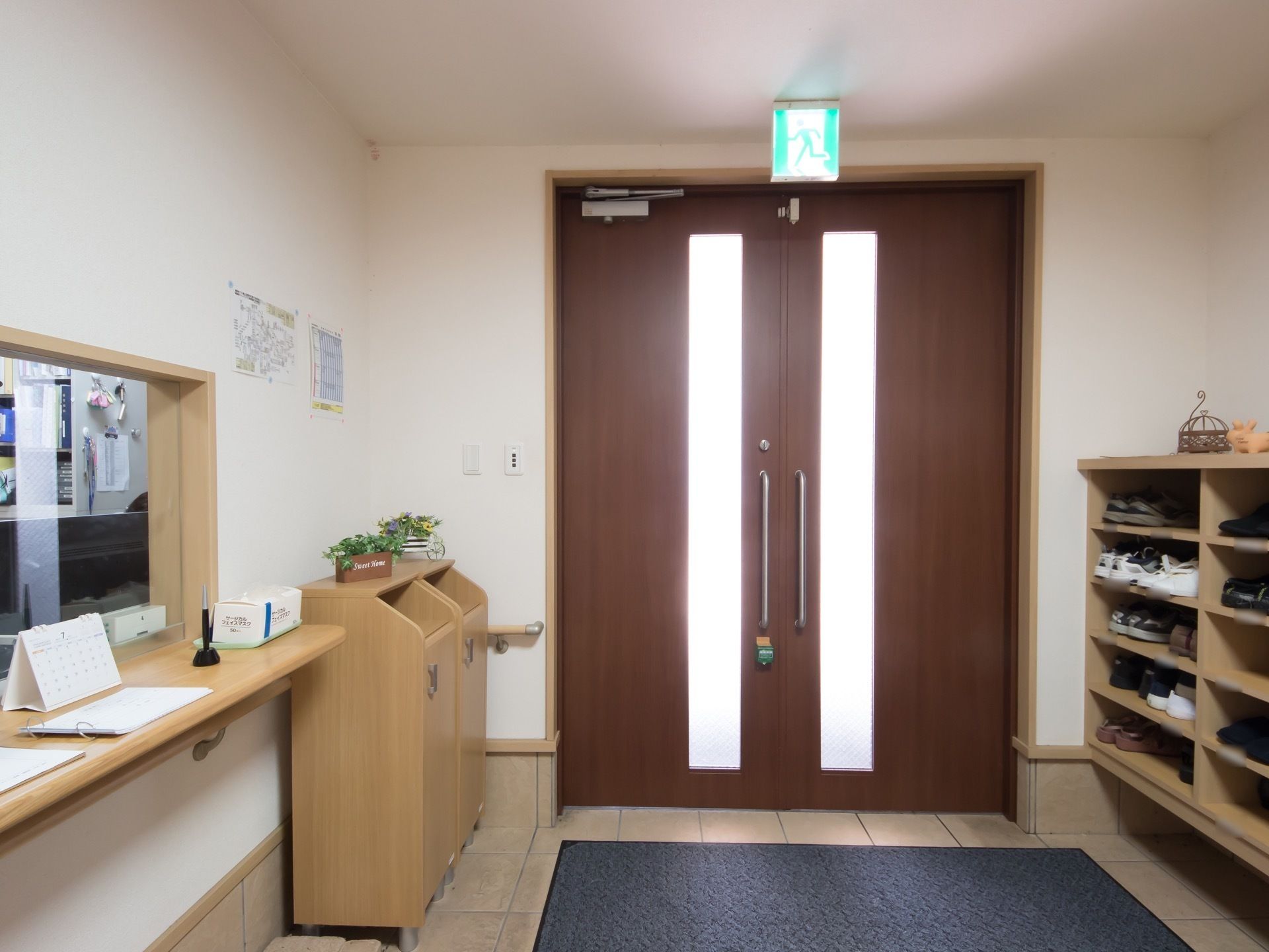 施設の玄関には、押し開きのドアが設置され泥落としマットが敷かれている。受付カウンターが設けられている。