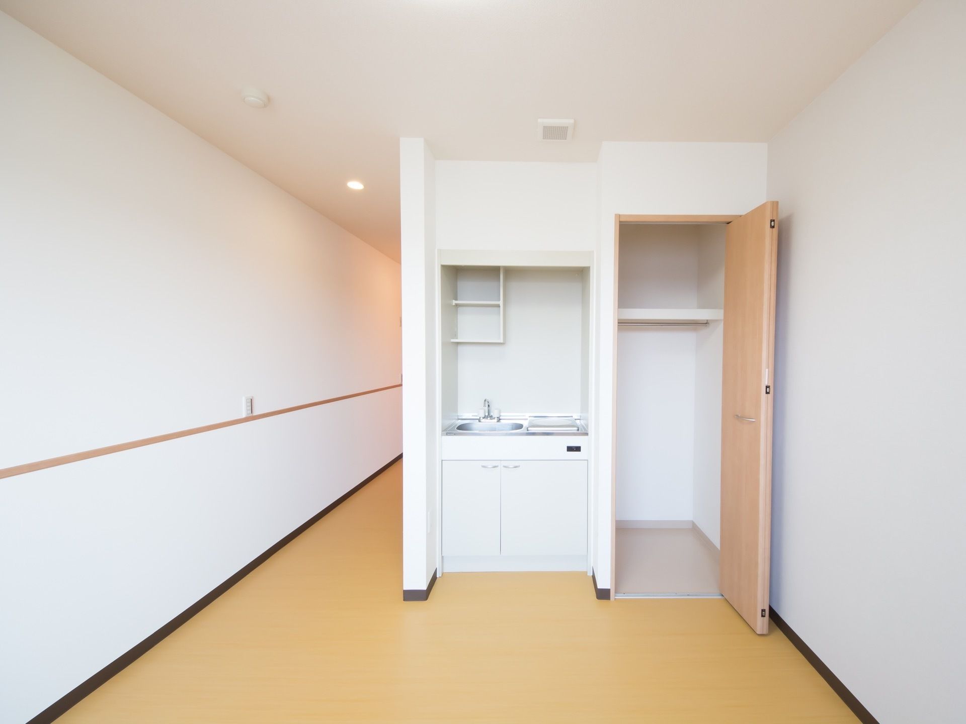 居室内に完備されている収納クローゼットである。明るい木目調の片開きの折り畳み式扉で、中は仕切り棚が造られている。