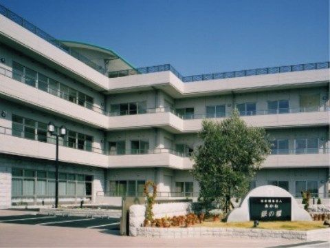 3階建て施設を背景に完備された花壇内の施設モニュメント