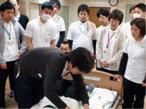 複数人のスタッフと施術を指導中の講師による研修風景