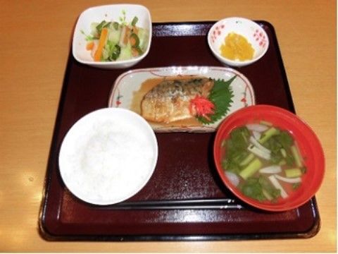 茶系の盆にお箸と共に並べられている一汁三菜の食事メニュー