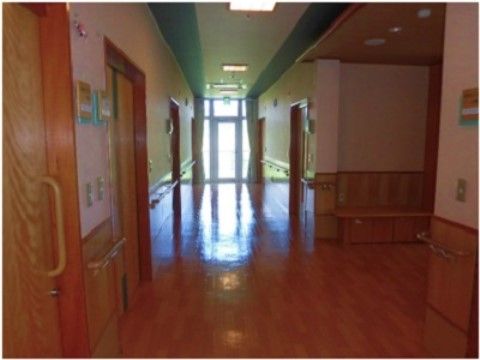 「グループホームあかぎ」の廊下。フラットな床に、介助手すりを左右に設置し、入居者様の不安を取り除いている。